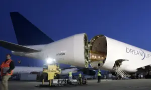 Ein Frachtflugzeug mit geöffneter Nase, bereit, Träume zu transportieren. Der Schriftzug "Dream Lifter" prangt auf dem Rumpf.