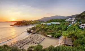Sonnenuntergang am Club Marvy: Ein Strand mit vielen Liegen, ein Wasserpark und üppige Vegetation.