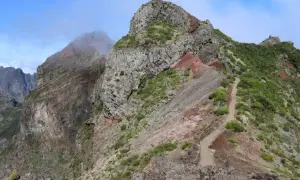 Steiler Wanderweg auf Madeira, ideal für die Packliste. Felsen und grüne Vegetation prägen die Landschaft.