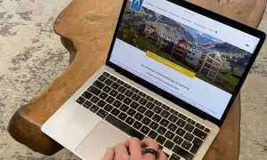 Laptop zeigt Webseite für Ferienhäuser in den Alpen. Perfekt für die einkaufsliste urlaub selbstversorger.
