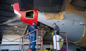 Zwei Mechaniker auf einer Hebebühne arbeiten am Triebwerk eines Flugzeugs. Ein wichtiger Begriff aus der Fliegerei wird hier greifbar.