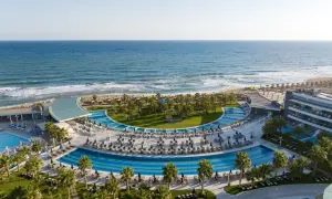 Traumhafter Blick auf das Lyttos Mare auf Kreta: Palmen, Pools und das azurblaue Meer.