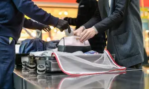 Sicherheitskontrolle am Flughafen: Medikamente werden aus einer Kosmetiktasche genommen, bevor das Gepäck in den Flugzeug-Container kommt.