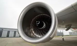 Detailaufnahme eines riesigen Triebwerks der A380. Im Hintergrund die Airbus-Halle und eine Person in Warnweste.