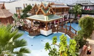 Tropisches Paradies im Sieben Welten Hotel & Spa Resort: Poollandschaft mit asiatischem Flair, Bar und Palmen.