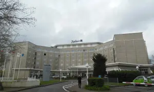 Das Radisson Blu Hotel Dortmund, ein imposantes Gebäude mit vielen Fenstern, empfängt seine Gäste unter einem grauen Himmel.