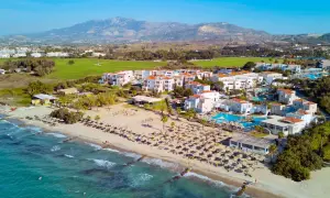 TUI Magic Life Marmari Palace: Traumhafter Strandurlaub mit türkisblauem Meer, weißen Gebäuden und Bergen im Hintergrund.