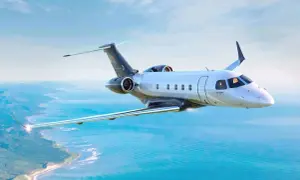 Ein modernes Privatflugzeug fliegt über dem Meer. Die Frage, wie viel kostet ein Passagierflugzeug, ist komplex, aber dieses Modell ist ein Luxusgut.