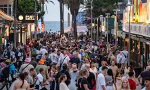 Volle Promenade auf Mallorca, viele Menschen unterwegs. Die Tourismussteuer auf Mallorca wird diskutiert, während Urlauber das Nachtleben genießen.