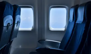 Leere Flugzeugsitze mit Blick auf den blauen Himmel. Eine Sitzplatzreservierung im Flugzeug ist sinnvoll, um den besten Platz zu sichern.