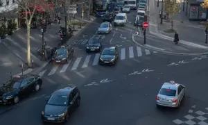 Verkehr in Paris: Autos und Taxis auf dem Weg zum Ziel. Ein silbernes Taxi fährt über den Zebrastreifen, während andere Fahrzeuge im Stau stehen.