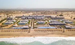Luftaufnahme des Riu Palace Boavista Hotels mit mehreren Gebäuden, Pools und einem Strand mit Sonnenschirmen.