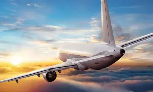 Ein Flugzeug fliegt über Wolken bei Sonnenuntergang. Die Frage, wie sicher ist fliegen aktuell, wird durch diese friedliche Szene beantwortet.