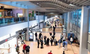 Menschen im Hamburger Flughafen, einige eilen zu ihren Gates, andere suchen nach Möglichkeiten, Geld zu wechseln.
