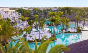Traumhafter Poolbereich im TUI Kids Club Maspalomas Princess mit Palmen und Liegen.