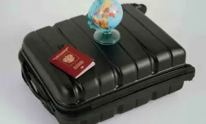 Reisekoffer mit Reisepass und Globus. Wo kann man Geld wechseln? Am Flughafen oder in der Bank.