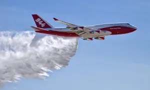 Eine Boeing 747, die als Global Supertanker zur Brandbekämpfung eingesetzt wird, sprüht Wasser. Sie fliegt schnell, um Brände zu löschen.