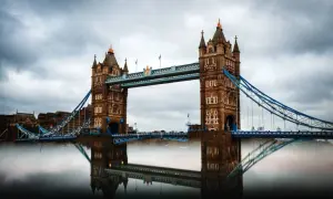 Der Tower Bridge in London, ein Wahrzeichen für jeden England Urlaub, spiegelt sich im Wasser.