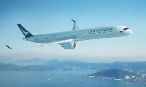 Cathay Pacific Sicherheit: Ein modernes Flugzeug fliegt über einer Stadt und dem Meer.