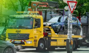 Gelber ADAC Abschleppwagen mit dunklem SUV auf der Ladefläche in Berlin. Informiert über die Kosten für Abschleppen in Berlin.