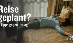 Mann liegt erschöpft im Bett nach Reise von West nach Ost. 4 Tipps gegen Jetlag.