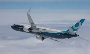 Boeing 737 MAX im Flug, ein Beispiel für sicherste Flugzeuge, mit blau-weißer Bemalung und dem Logo auf dem Heck.