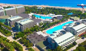 Luftaufnahme des von Resort Golden Coast, mit mehreren Gebäuden, Pools und dem Meer im Hintergrund.