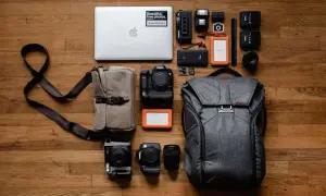 Perfekte work and travel packliste: Laptop, Kameras, Objektive, Speicherkarten, externe Festplatten, Blitzgeräte und ein Rucksack.