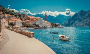 Traumhafte Küstenstadt mit roten Dächern und Booten im türkisfarbenen Wasser. Ein perfektes Beispiel für Urlaubsziele in Europa.