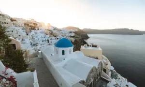 Ein malerischer Blick auf Oia, Santorini, mit seinen weiß getünchten Häusern und der ikonischen blauen Kuppelkirche. Perfekt für einen Santorini Urlaub.