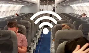 WLAN im Flugzeug: Passagiere sitzen in Reihen auf Flugzeugsitzen, während ein großes WLAN-Symbol über ihnen schwebt.