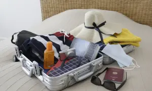 Packliste Istanbul: Koffer mit Badesachen, Sonnencreme, Kamera, Hut, Buch, Masken, Reisepass und Sonnenbrille.