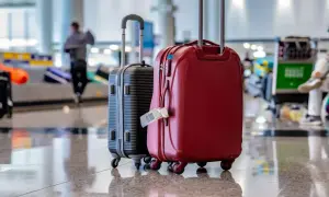 Zwei Koffer, rot und schwarz, stehen bereit für eine Kofferversteigerung in Berlin. Ein Gepäckanhänger hängt am roten Koffer.