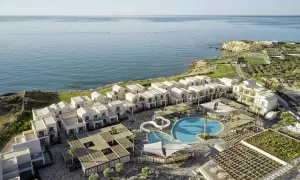 Robinson Ierapetra: moderne Anlage mit weißen Häusern, Pools und Blick aufs Meer.