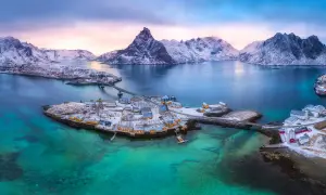 Winterliche Lofoten: Ein Traum für jeden Skandinavien Urlaub. Schneebedeckte Berge, türkisfarbenes Wasser und malerische Fischerdörfer.
