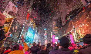 Konfetti regnet auf die Menge am Times Square. Ein Feuerwerk erhellt den Himmel, während die Menschen den Jahreswechsel feiern. Silvester in New York ist ein unvergessliches Erlebnis.