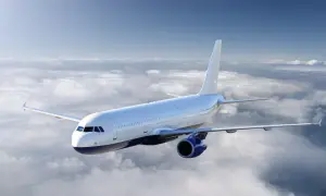 Ein weißes Flugzeug fliegt über einer Wolkendecke. Die Sonne scheint, aber die Wolken deuten auf mögliche Flugzeugturbulenzen hin.