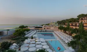 Ein luxuriöses Resort am Elios Hill Kreta mit Pools, Wasserrutschen und Blick aufs Meer. Sonnenschirme und Liegen laden zum Entspannen ein.