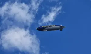 Ein Goodyear-Zeppelin schwebt am blauen Himmel. Wie viele Zeppeline es gibt, ist unklar, aber dieser hier ist gut sichtbar.