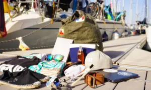 Packliste Segeln: Kleidung, Sonnenbrille, Zahnbürste, Gürtel, Laptop und eine Tasche. Bereit für das Abenteuer auf dem Wasser!