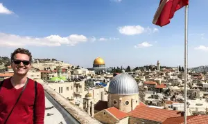 Glücklicher Mann genießt seinen Urlaub in Israel mit Blick auf die Altstadt von Jerusalem und den Felsendom.