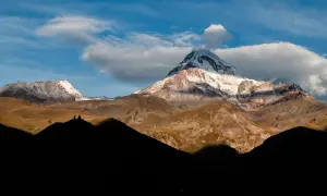 Majestätische Berge in Georgien, ein unvergesslicher Urlaub. Die Gergeti-Dreifaltigkeitskirche thront auf einem Hügel vor dem schneebedeckten Gipfel des Kasbek.