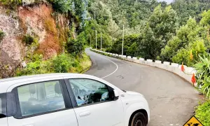 Ein weißer Mietwagen auf einer kurvigen Straße auf Madeira. Braucht man auf Madeira einen Mietwagen? Ja, um diese Aussicht zu genießen!