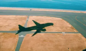 Schatten eines Flugzeugs auf dem Rollfeld. Gute tipps langstreckenflug: entspannt bleiben, Wasser trinken, bewegen.
