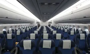 Reihe von blauen Flugzeugsitzen mit weißen Kopfstützen. Ein Sitzplatz D ist in der Mitte des Bildes zu sehen.