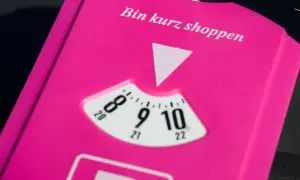 Pink parkschein mit der Aufschrift "Bin kurz shoppen". Die Parkscheibe ist auf 9 Uhr eingestellt.