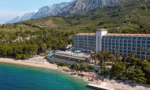 TUI Blue Jadran: Ein Hotel am Strand mit Pool und Bergen im Hintergrund, an der türkisfarbenen Adria.