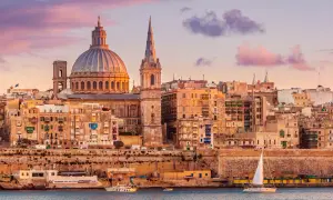 Sonnenuntergang über Valletta, Malta. Die Kuppel der St. Paul's Cathedral und die St. John's Co-Cathedral dominieren die Skyline. Ein perfekter Ort für einen Urlaub.