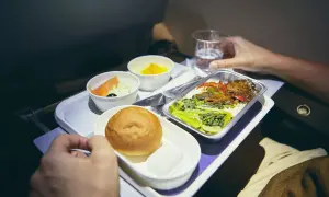 Flugzeugessen: Ab wann gibt es Essen? Ein Tablett mit Lachs, Brötchen, Dessert und Hauptgericht.
