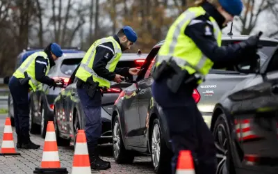 Polizisten kontrollieren Fahrzeuge an der Grenze zur Einreise in die Niederlande.